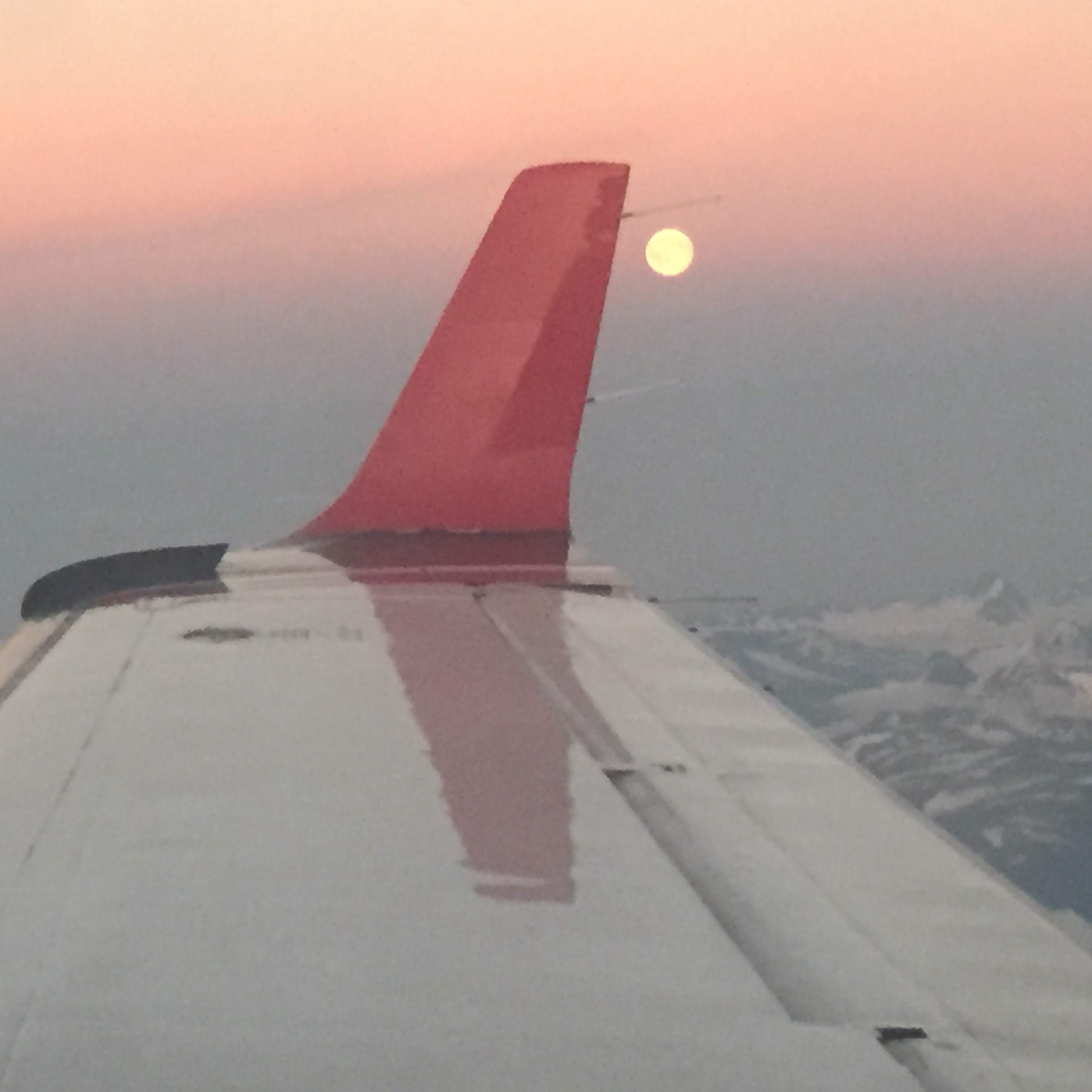 窗外的陽光與雪山——還未降落,北方旅程已經開始。